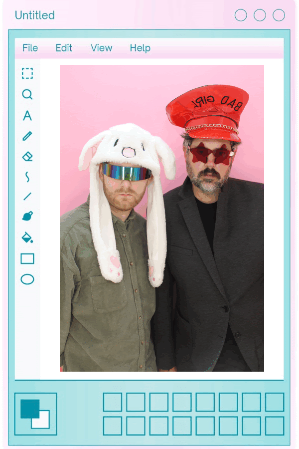 The two Brians against a pink wall, one in a fluffy bunny hat and visor, the other in a red 'Bad Girl' cap and star sunglasses, framed in a retro paint-program window.